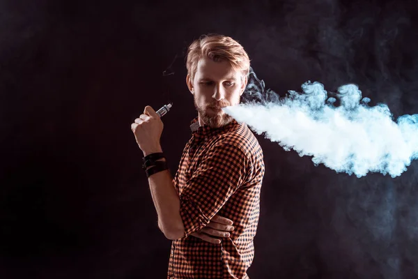 Genç adam elektronik sigara içiyor. — Stok fotoğraf