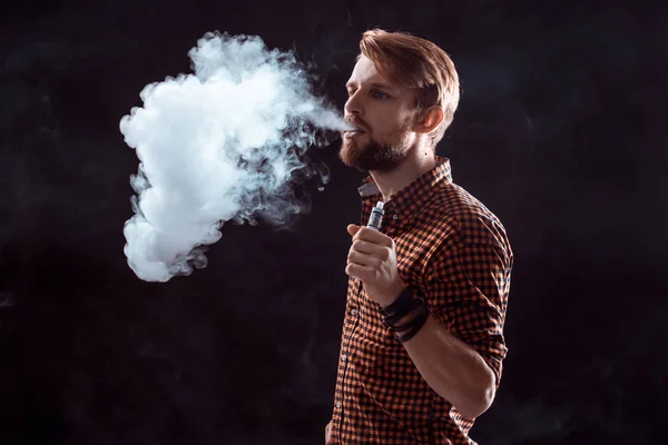 Молодий чоловік курить електронну сигарету — стокове фото