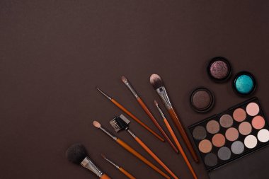 Gerekli kadar olun. Fırçalar, kremler ve gölgeler kavanoz koyu arka plan üzerinde profesyonel makyaj seti.