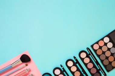 Gerekli kadar olun. Fırçalar, kremler ve gölgeler kavanoz mavi zemin üzerine profesyonel makyaj seti.