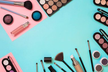 Gerekli kadar olun. Fırçalar, kremler ve gölgeler kavanoz mavi zemin üzerine profesyonel makyaj seti.