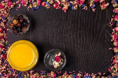 Organik bal ahşap arka plan üzerinde küçük bir kavanoz, çamur ve toprak toz içinde. Çerçeve kurutulmuş çiçek