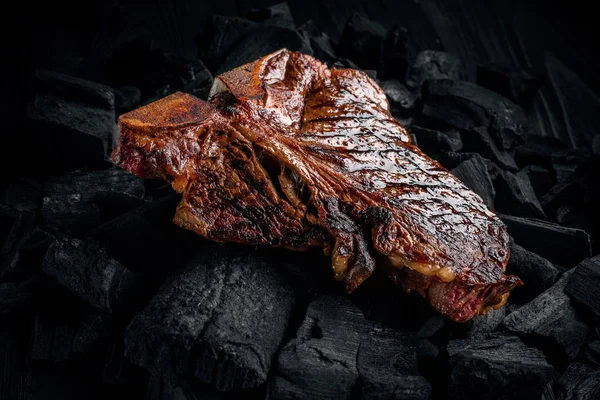 Grilling a tasty tender marinated t-bone steak on a coals. Close up view — Stock Photo, Image