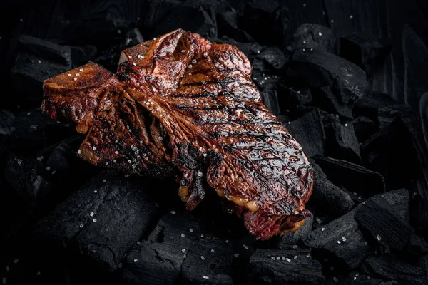 Grilling a tasty tender marinated t-bone steak on a coals. Close up view — Stock Photo, Image