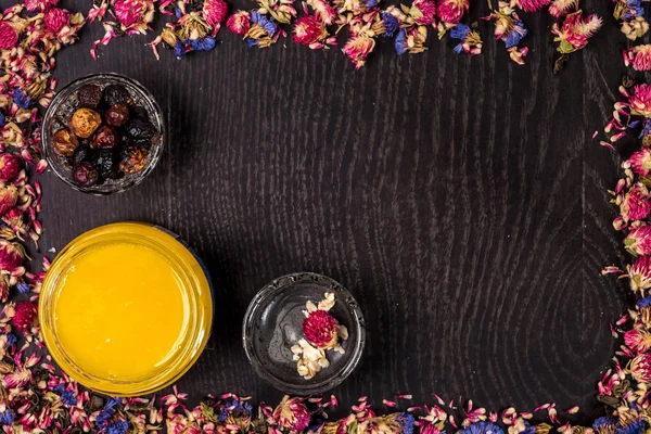 Organik bal ahşap arka plan üzerinde küçük bir kavanoz, çamur ve toprak toz içinde. Çerçeve kurutulmuş çiçek