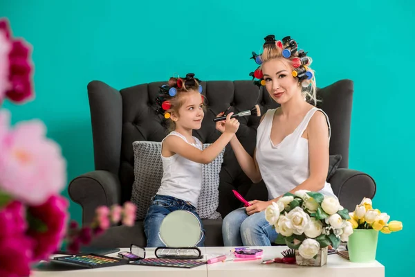 Anne ve kızı curlers içinde kanepede stüdyoda makyaj ve iyi eğlenceler — Stok fotoğraf