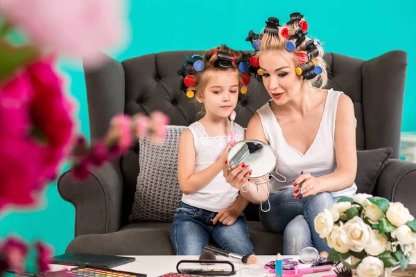 Anne ve kızı curlers içinde kanepede stüdyoda makyaj ve iyi eğlenceler