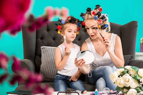 Мама и дочь в студии на диване в бигуди макияж и веселиться — стоковое фото