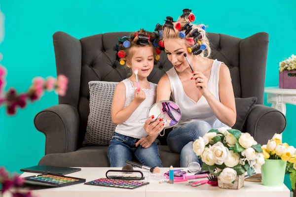 Anne ve kızı curlers içinde kanepede stüdyoda makyaj ve iyi eğlenceler