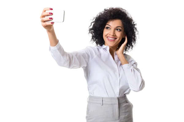 Όμορφη μελαχρινή γυναίκα στον κλασικό λευκό πουκάμισο και φούστα κάνει selfie στο τηλέφωνο. — Φωτογραφία Αρχείου