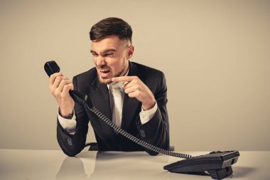 genç adam ofiste otururken telefon numarasını çevirir