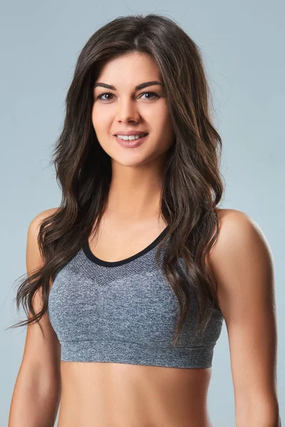 Güzel gülümseyen genç sporcumuz gri arka plan üzerinde duran gri üst ve siyah şort