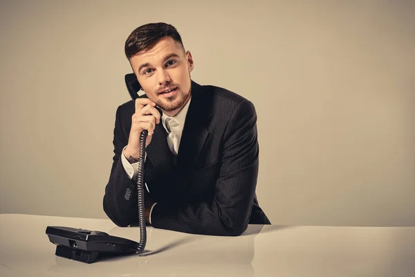 Молодий чоловік набирає номер телефону, сидячи в офісі — стокове фото