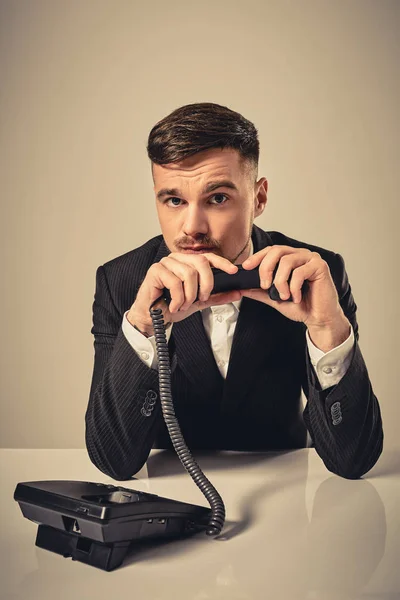 Молодий чоловік набирає номер телефону, сидячи в офісі — стокове фото