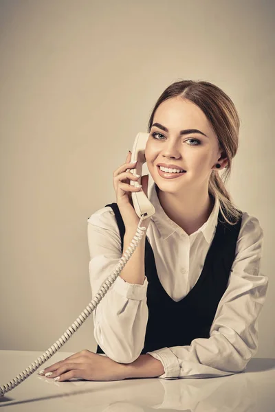 Retrato de jovem secretária atender telefone — Fotografia de Stock