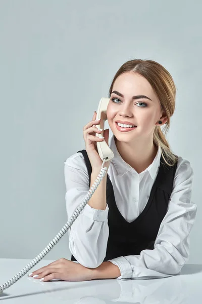 Retrato de jovem secretária atender telefone — Fotografia de Stock