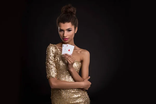 Woman winning - Young woman in a classy gold dress holding two aces, a poker of aces card combination. — Stock Photo, Image