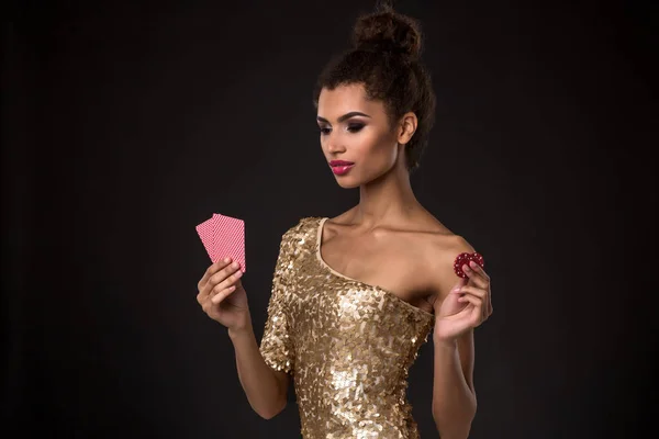 Žena vyhrál - mladá žena v elegantní zlaté šaty hospodářství dvě karty a dvě červené žetony, poker ACE karetní kombinace. — Stock fotografie