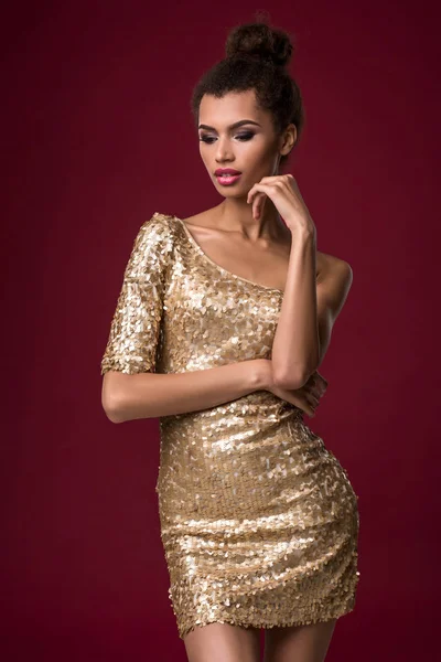 Módní mladá Afričanka s make-up, zkrátka sexy zlaté šaty. — Stock fotografie