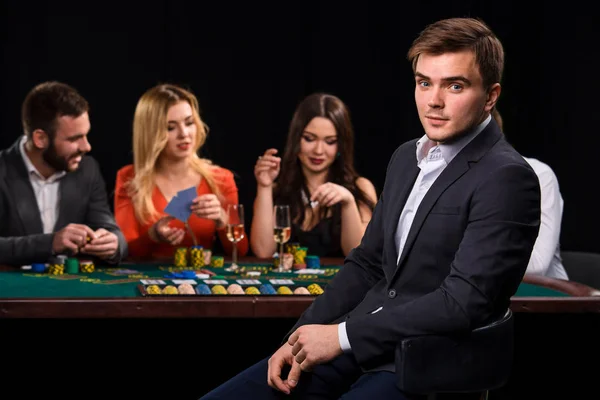 赌场里的扑克玩家，背景是黑色的卡片和芯片 — 图库照片