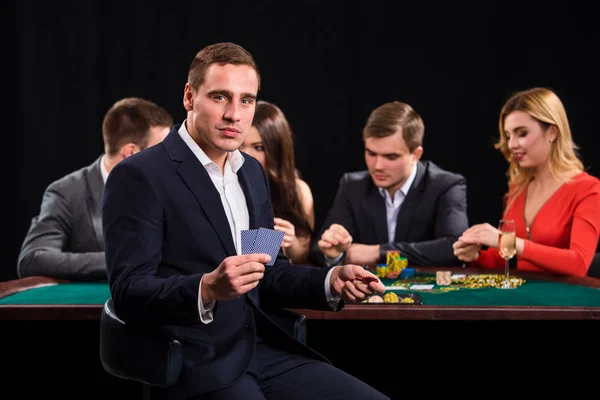 Kumarhanedeki poker oyuncularının siyah arkaplanda kartları ve çipleri var — Stok fotoğraf