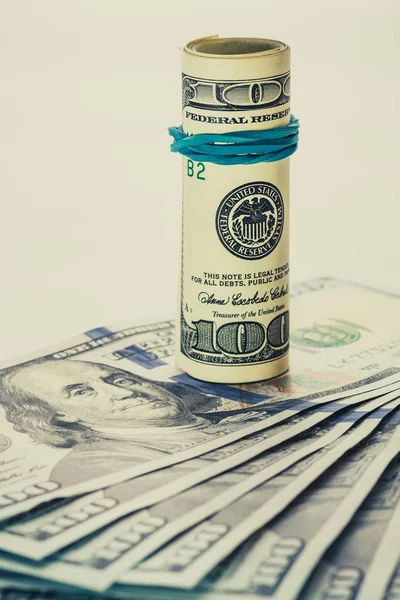 Başka bir açılı 100 doları duruyor bir sarmal 100 dolarlık banknot bill izole üzerinde beyaz arka plan