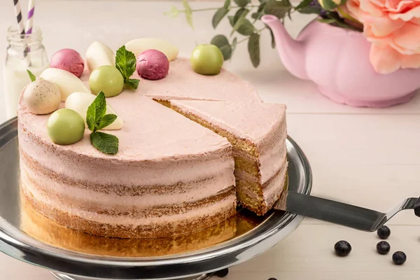 Ροζ τούρτα με δυόσμο και διακοσμητικά γλυκό μπάλες από πάνω σε ένα πιάτο, γκρο πλαν. — Φωτογραφία Αρχείου