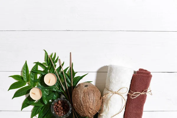 SPA still life with towel, candles and green leaves on a white wooden surface — Stock Photo, Image