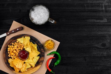 Lager bira ve siyah ahşap masa snacks. Kuruyemiş, cips. Üstten Görünüm ile boşaltmak