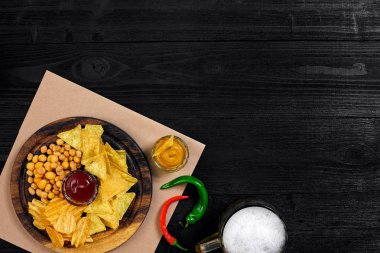 Lager bira ve siyah ahşap masa snacks. Kuruyemiş, cips. Üstten Görünüm ile boşaltmak