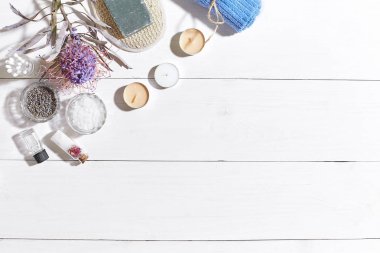 Beyaz ahşap zemin üzerinde kuru çiçek spa set deniz tuzu, uçucu yağ, sabun ve havlu ile süslenmiş