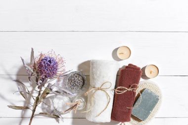 Beyaz ahşap zemin üzerinde kuru çiçek süslenmiş havlu ve sabun ile ayarla spa