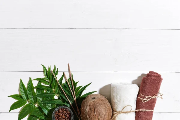 SPA still life with towel, candles and green leaves on a white wooden surface — Stock Photo, Image