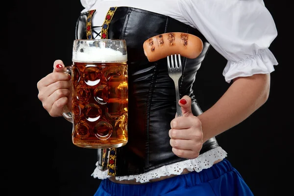Dirndl genç kadınla Oktoberfest bira stein tutar. Siyah arka plan üzerine.
