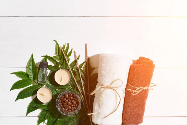 Spa natürmort havlu, mumlar ve yeşil bir beyaz ahşap yüzeye bırakır. Güneş parlaması