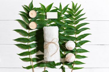 Spa set ile havlu ve sabun yeşil yaprakları ile beyaz ahşap zemin üzerinde