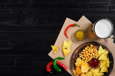 Lager bira ve siyah ahşap masa snacks. Kuruyemiş, cips. Üstten Görünüm ile boşaltmak