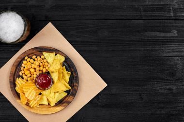 Lager bira ve siyah ahşap masa snacks. Kuruyemiş, cips. Üstten Görünüm ile boşaltmak