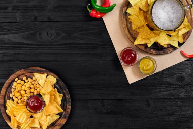 Lager bira ve siyah ahşap masa snacks. Kuruyemiş, cips. Üstten Görünüm ile boşaltmak