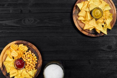 Lager bira ve siyah ahşap masa snacks. Kuruyemiş, cips. Üstten Görünüm ile boşaltmak