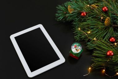 Tablet bilgisayar, Noel oyuncaklar, yıldız ve kabarık çam dalları olan tablo. Metin için özgür yer. Üstten Görünüm.