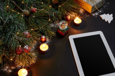 Tablet bilgisayar, Noel oyuncaklar, yıldız ve kabarık çam dalları olan tablo. Metin için özgür yer. Üstten Görünüm.
