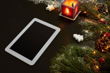 Tablet bilgisayar, Noel oyuncaklar, yıldız ve kabarık çam dalları olan tablo. Metin için özgür yer. Üstten Görünüm.