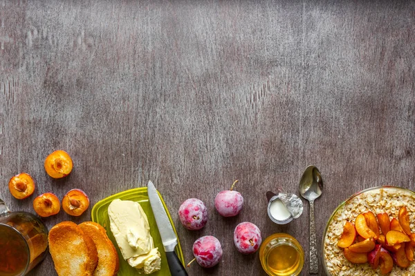 Yulaf ezmesi Erik, tereyağı ve ahşap bir masa üzerinde ballı ekmek. Sağlıklı bir kahvaltı kavramı