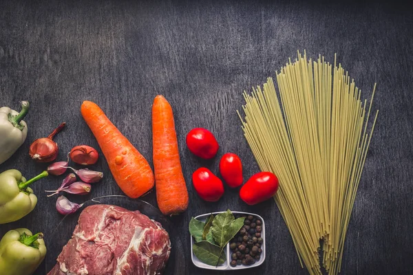 Spagetti, taze organik sebze, soğan, sarımsak, baharatlar, karabiber, biberiye, tuz, domates ve makarna yemek pişirmek için dereotu ile çiğ et Dana. Üstten Görünüm.