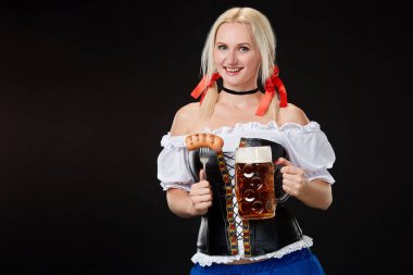 Dirndl bira bardağı siyah arka plan üzerine ile giyen genç seksi kadın.