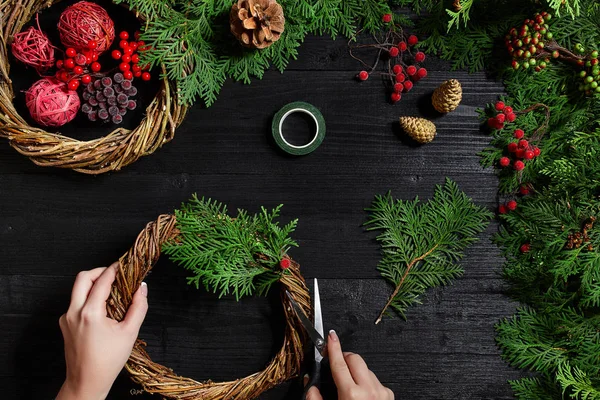 Fabricante de decoração de Natal com suas próprias mãos. Grinalda de Natal para o feriado. A celebração do ano novo. Vista superior — Fotografia de Stock