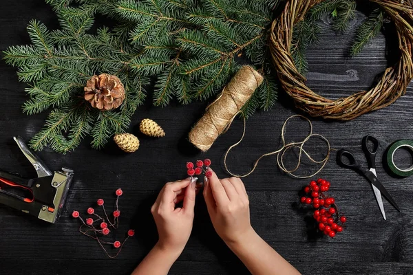 Fabricante de decoração de Natal com suas próprias mãos. Grinalda de Natal para o feriado. A celebração do ano novo. Vista superior — Fotografia de Stock