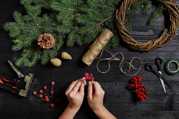 Fabricante de decoração de Natal com suas próprias mãos. Grinalda de Natal para o feriado. A celebração do ano novo. Vista superior — Fotografia de Stock