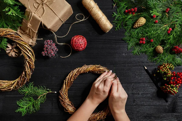 Fabricante de decoração de Natal com suas próprias mãos. Grinalda de Natal para o feriado. A celebração do ano novo. Vista superior — Fotografia de Stock